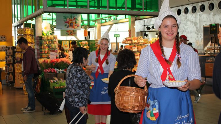 Alkmaarse kaasmeisjes delen 20.000 blokjes kaas uit op Schiphol