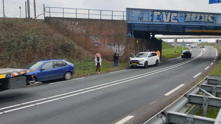 Automobilist rijdt onder spoorbrug N242 in op file