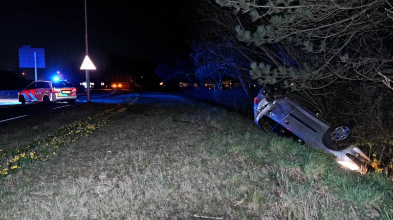 Auto over de kop op Herenweg, bestuurder vlucht met hulp van scooterrijder