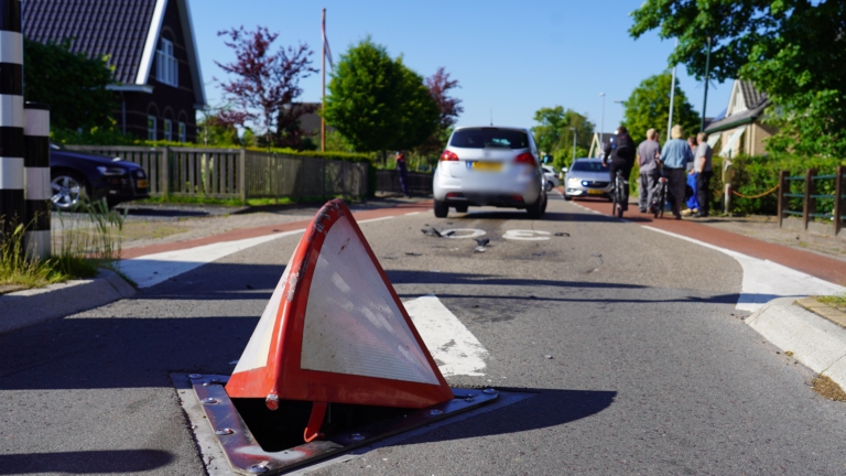Vrouw rijdt over beweegbare driehoek in Herenweg te Oudorp