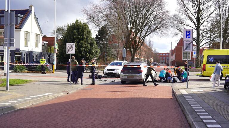 Verkeersongeluk met meerdere voertuigen, politie en medisch personeel aanwezig, afzetlint en ambulance ter plaatse.