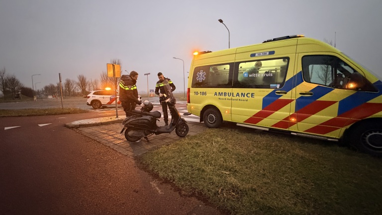 Politieagenten staan naast een scooter voor een ambulance bij zonsopgang of zonsondergang.