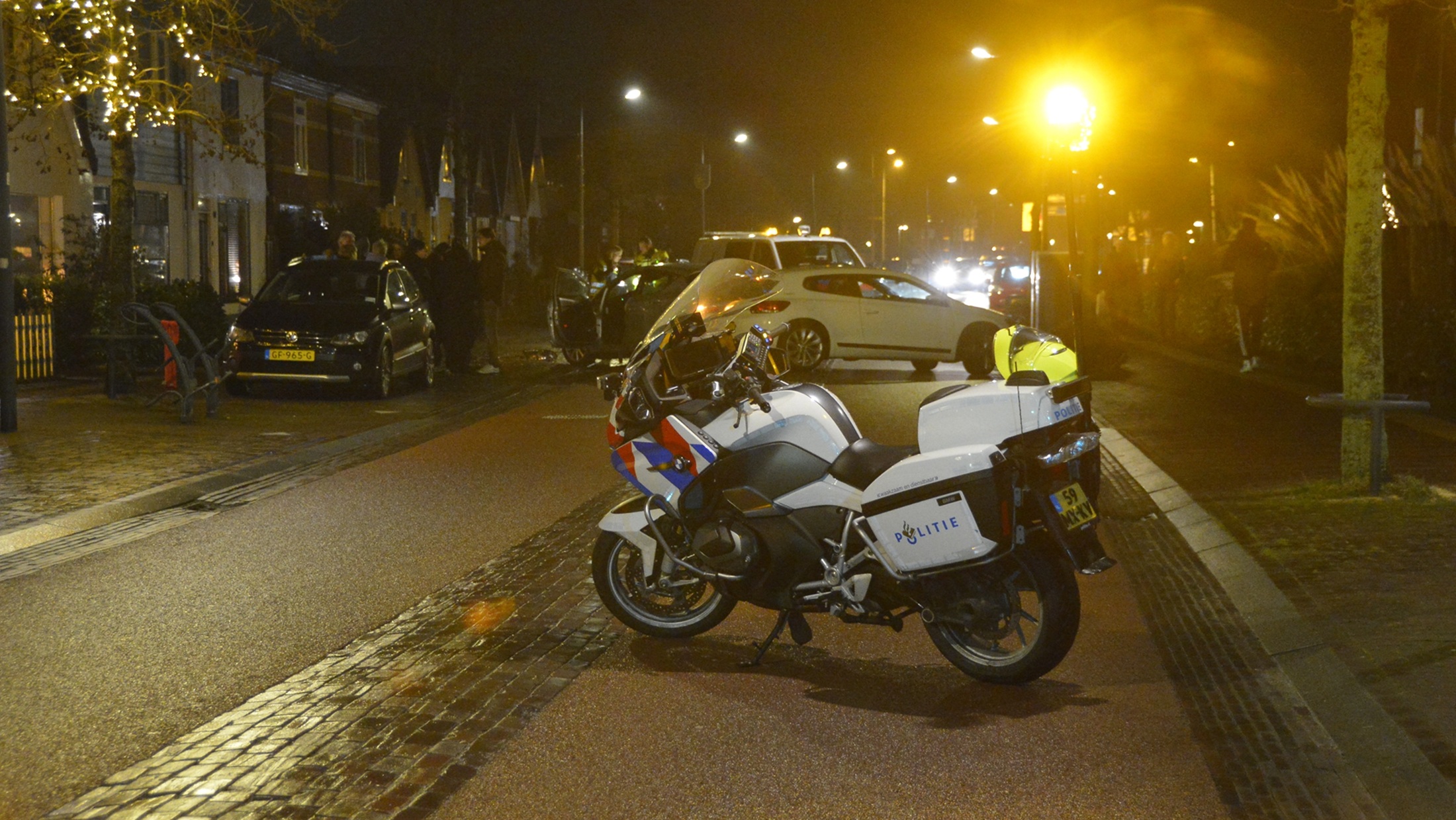 Twee auto's betrokken bij een botsing op een straat 's nachts, met zichtbaar schade aan de voorzijde van de zilveren auto.