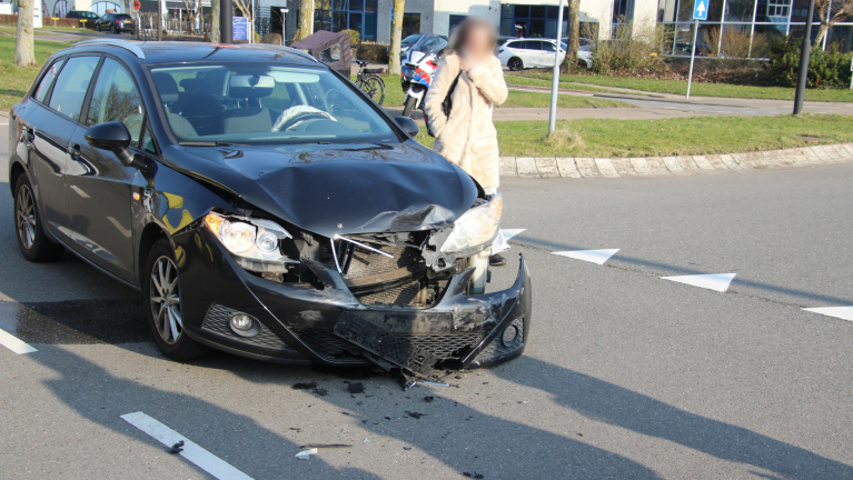 Auto ligt ondersteboven op straat na ongeval, omringd door hulpverleners, met een brandblusser op de voorgrond.