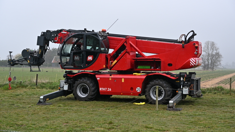 Brandweerlieden redden een koe uit een sloot, met meerdere mensen die toezicht houden in een landelijke omgeving.