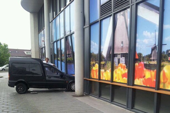 Vrouw parkeert bestelauto in gevel leegstaande winkel (FOTO'S)